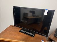 Sony Bravia KDL-46XBR9 46-inch TV on a wooden surface with two remote controls in front of it.