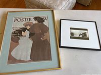 Two framed prints on a table, showing "Poster Show" poster and black and white photo.