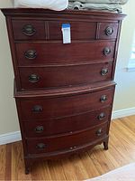Full front view of vintage campaign style double dresser showing six drawers and wooden frame with metal handles on hardwood floor