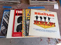 Five vinyl records laid out showing covers of The Beatles HELP! soundtrack and Paul McCartney RAM album and others.