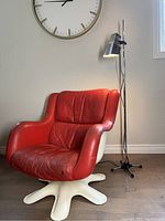 Front view of red leather lounge chair with white fiberglass base and lamp