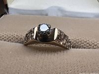 Front view showing round diamond set in six-prong crown and textured band