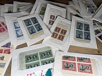Multiple blocks and sheets of vintage Canadian stamps in protective sleeves, mainly blue, green, red, and brown stamps.