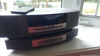 Front view of stacked Bose Wave Music System components with remote on top