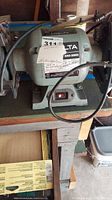 Full side view of the Delta 6 inch bench grinder showing power switch, label and mounting base.