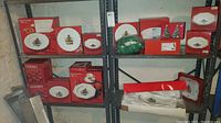 Four metal shelving units with multiple boxed and unboxed Nikko Christmastime plates and bowls decorated with Christmas tree designs