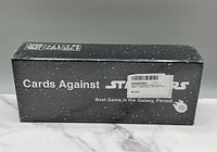 Side view of the boxed Cards Against Star Wars game, sealed and new, showing branding and game title.