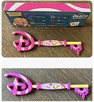 Photo showing the collectible key and its box featuring Alice in Wonderland themed artwork and the key itself with Cheshire Cat design.