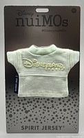 Front view of Disney Nuimos Spirit Jersey in light green with embroidered Disneyland Paris logo on branded backing card.