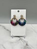 Pair of vintage gold-tone dangle earrings with multicolor enamel hoops on white card display.