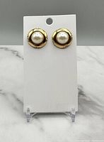 Pair of vintage gold-tone earrings with faux pearls on a white display card.