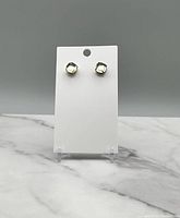 Pair of vintage-style clear faceted stone stud earrings on white card, photo front view