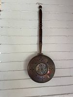 Front view of the copper bed warmer showing decorative perforated pan and wooden handle.