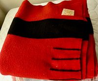 Folded red and black Hudson’s Bay Four Point blanket