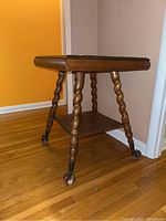 Full side view of the wooden square table with twisted legs and lower shelf
