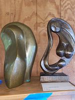 Both sculptures side by side on shelf