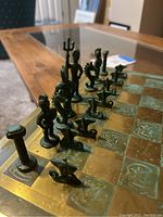 Close view of one side of board showing green patina pieces and square detail