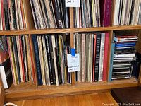 Bottom shelf with vinyl records mostly of classical music and folk anthologies with a label 'Lot #55 albums + contents shelf 2'.