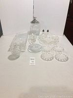 Photo showing entire collection of Mikasa and other clear glassware on white background, arranged with canape tray, bowl set, candle holders, salt and pepper shakers, canister, and other items.