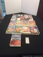 Collection of 18 VHS movies including Disney titles arranged on black surface