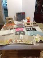 Wide view showing all papers, binders, boxes, Winnie the Pooh bank, and colored pencils arranged on table