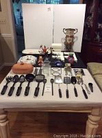 Overview of the full assortment laid out on table, showing utensils in front, onion roaster, rooster platter, and various decorative pieces in back.