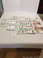 Overview showing 15 scrapbook paper pads arranged on table, mostly 6x6 inch size pads with some 5x7 inch pads. Various colorful patterned designs visible.