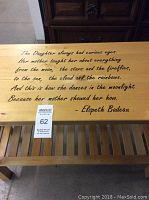 Close-up of vinyl quote on top of blonde wood table with a poetic saying by Elspeth Badeau.