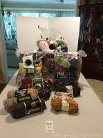 Photo showing three large space bags filled with assorted yarn skeins and extra skeins arranged in front including homespun brand yarn.