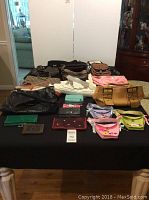 Full table view showing variety of purses and wallets in multiple colors and styles