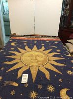 Large blue blanket with sun and moon design spread out on a surface