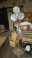 Full view of the vintage industrial standing fan showing its height and surroundings.