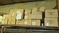 Wide view of stacked cardboard boxes containing gift boxes on metal shelving