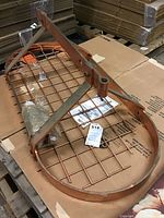 Full view of copper hanging rack with metal grid base and support brackets placed on cardboard.