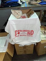 Box of white cotton rags with red printed logo 'E D Lrosa-Greenwal Cenex Land O Lakes Farm Service Center' on top rag, showing contents and condition