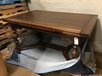 Full view of the dining table showing the rectangular wooden top and carved legs.