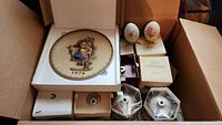 Full lot in box showing Hummel plate, ornaments, and boxes.