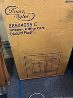 Original cardboard box packaging of the Home Styles kitchen utility cart showing brand name and product details.