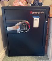 Front view of a black Sentry Safe with digital keypad lock and silver handle, showing the logo and access handle.