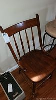 Vintage wooden chair with curved backrest and spindle design in brown wood finish