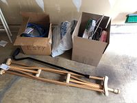 Photo of crutches, black cane, and two boxes containing various health-related items including cold water circulator and accessories.