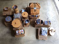 Overview of the full lot showing multiple boxed Longaberger Collectors Club miniature baskets and accessories arranged on the floor.