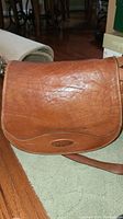 Front view of brown leather Oroton purse with flap and logo patch