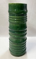 Front view of the tall green ribbed pottery vase showing overall shape and glaze.