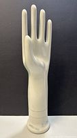 Front view of the porcelain glove mold showing fingers and thumb upright, glossy white surface, size and model markings visible near base.