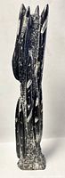 Front view of the elongated black polished Orthoceras fossil sculpture with embedded white fossil patterns.