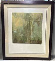 Framed art print showing an abstract nature scene with trees in green and beige tones, signed and numbered 17/950.