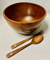 Full view of wooden salad bowl with two wooden salad tongs, showing the sterling silver plaques on the handles.