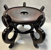Front angle showing carved rosewood pedestal with curved legs and circular top with central hole.