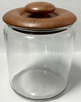 Front and side view of the clear glass jar with smooth rounded edges and natural teak wood lid with knob.